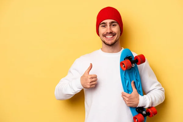 Young Skater Caucasian Man Isolated Yellow Background Smiling Raising Thumb — Zdjęcie stockowe