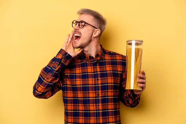 Young Caucasian Man Holding Spaghettis Jar Isolated Yellow Background Shouting — Stock fotografie