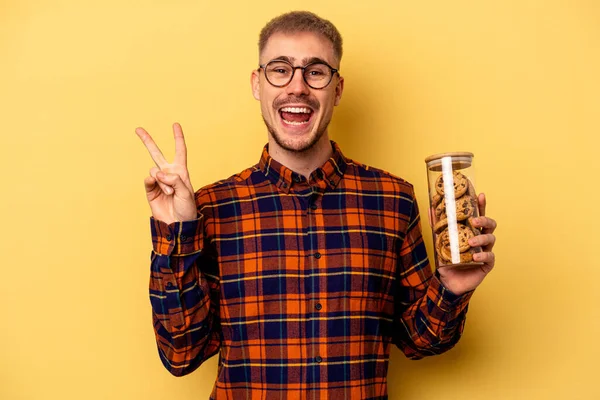 Young Caucasian Man Holding Cookies Jar Isolated Yellow Background Joyful — Stock fotografie