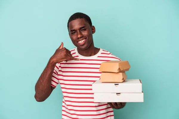 Mladý Afroameričan Drží Pizzy Hamburgery Izolované Modrém Pozadí Ukazující Gesto — Stock fotografie