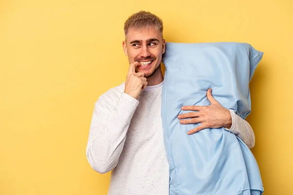 Young Caucasian Man Wearing Pajama Holding Pillow Isolated Yellow Background — Stock Fotó