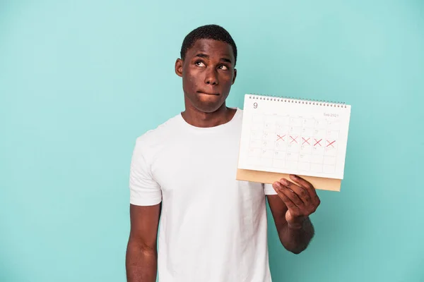 Jonge Afro Amerikaanse Man Met Een Kalender Geïsoleerd Blauwe Achtergrond — Stockfoto