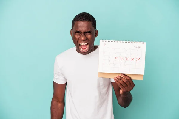 Mladý Africký Američan Drží Kalendář Izolované Modrém Pozadí Křičí Velmi — Stock fotografie