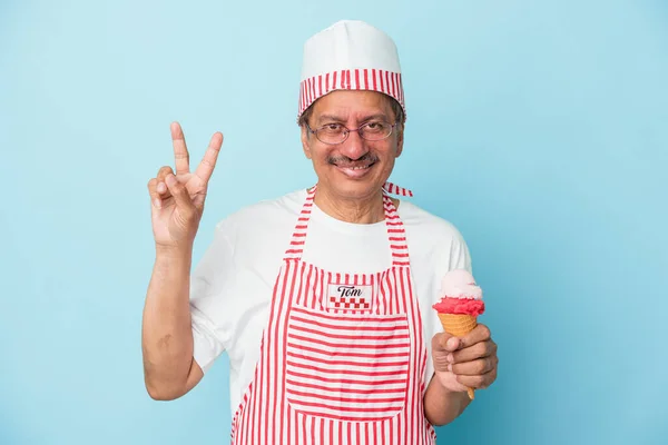 Senior american ice cream man holding an ice cream isolated on blue background showing number two with fingers.