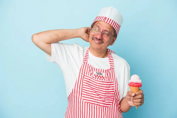 Старший Американский Мороженщик Держит Мороженое Изолированное Синем Фоне Трогает Затылок — стоковое фото