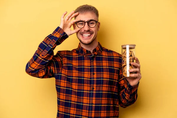 Young Caucasian Man Holding Cookies Jar Isolated Yellow Background Excited — ストック写真
