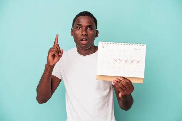 Jonge Afro Amerikaanse Man Met Een Kalender Geïsoleerd Blauwe Achtergrond — Stockfoto