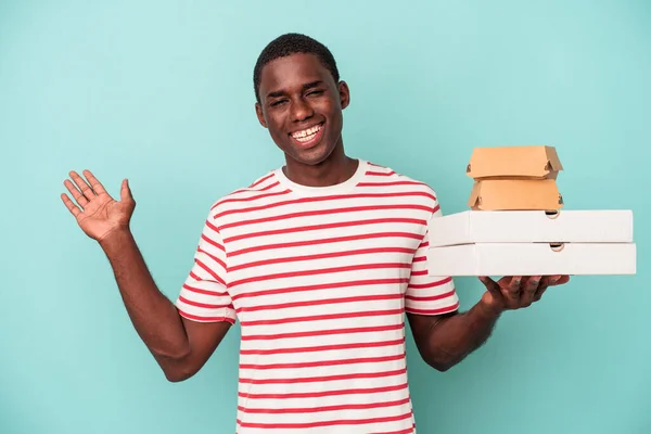 Jonge Afro Amerikaanse Man Met Pizza Hamburgers Geïsoleerd Blauwe Achtergrond — Stockfoto