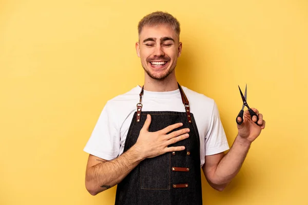 Young Caucasian Hairdresser Man Holding Scissors Isolated Yellow Background Laughs — 图库照片