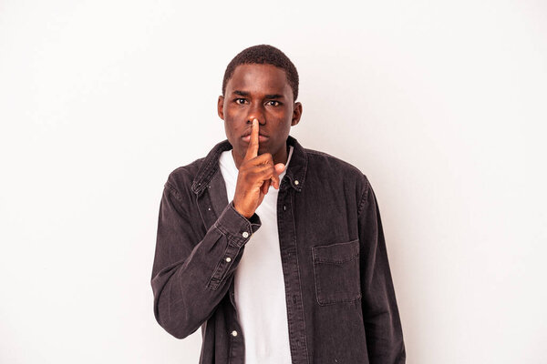 Young African American man isolated on white background keeping a secret or asking for silence.