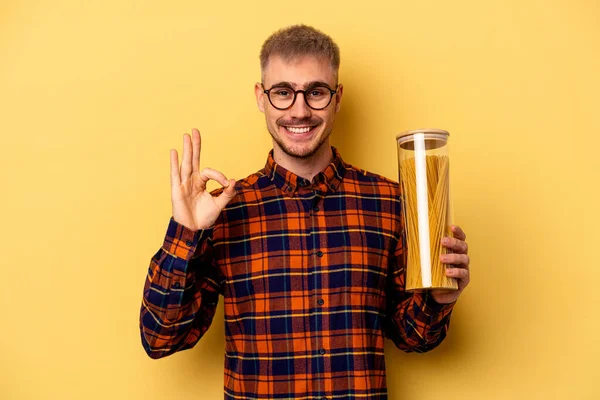 Joven Hombre Caucásico Sosteniendo Tarro Spaghettis Aislado Sobre Fondo Amarillo —  Fotos de Stock