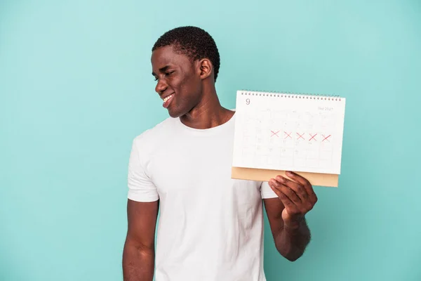 Jonge Afro Amerikaanse Man Met Een Kalender Geïsoleerd Blauwe Achtergrond — Stockfoto