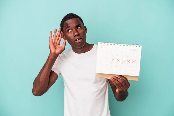 Jonge Afro Amerikaanse Man Met Een Kalender Geïsoleerd Blauwe Achtergrond — Stockfoto