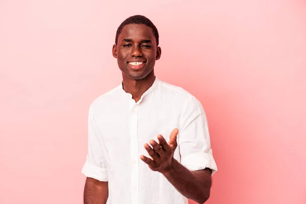 Mladý Africký Američan Izolovaný Růžovém Pozadí Strečink Ruku Kameru Pozdrav — Stock fotografie