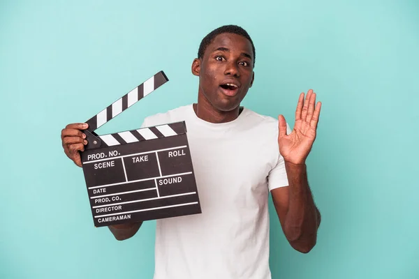 Young African American Man Holding Clapperboard Isolated Blue Background Surprised — Stock Photo, Image