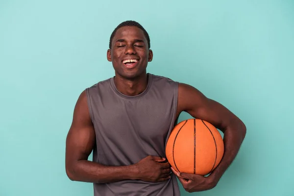 Joven Afroamericano Jugando Baloncesto Aislado Sobre Fondo Azul Riendo Divirtiéndose — Foto de Stock