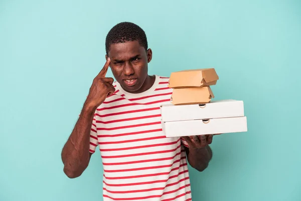 Mladý Afroameričan Drží Pizzy Hamburgery Izolované Modrém Pozadí Ukazuje Zklamání — Stock fotografie