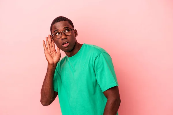 Ung Afrikansk Amerikansk Man Isolerad Rosa Bakgrund Försöker Lyssna Ett — Stockfoto