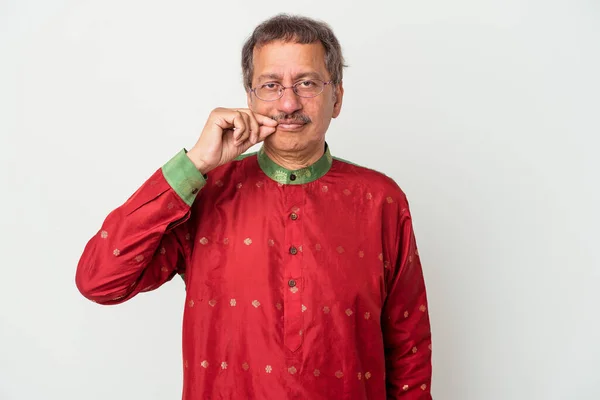 Senior indian man wearing a Indian costume isolated on white background with fingers on lips keeping a secret.