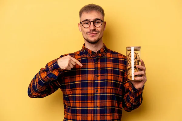 Mladý Kavkazský Muž Drží Cookies Sklenice Izolované Žlutém Pozadí Osoba — Stock fotografie