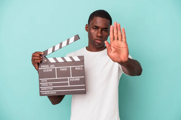 Jonge Afro Amerikaanse Man Houdt Clapperboard Geïsoleerd Blauwe Achtergrond Staan — Stockfoto