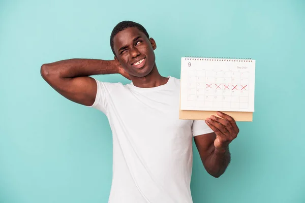 Jonge Afro Amerikaanse Man Houdt Een Kalender Geïsoleerd Blauwe Achtergrond — Stockfoto