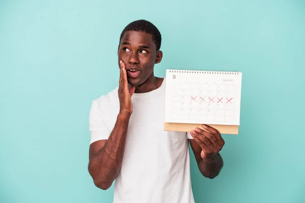 Mladý Afroameričan Drží Kalendář Izolovaný Modrém Pozadí Říká Tajné Horké — Stock fotografie