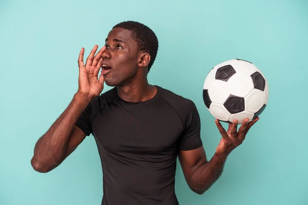 Młody Afroamerykanin Gra Piłkę Nożną Odizolowany Niebieskim Tle Krzycząc Trzymając — Zdjęcie stockowe