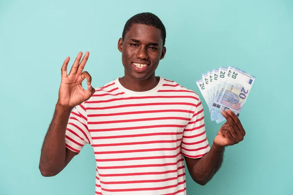 Молодой Афроамериканец Держащий Банкноты Синем Фоне Веселый Уверенный Себе Показывающий — стоковое фото