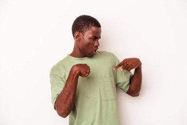 Beyaz arka planda izole edilmiş genç bir Afro-Amerikan erkeği parmağını gösterip gülümseyerek şaşırdı..