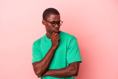 Pembe arka planda izole edilmiş genç Afrikalı Amerikalı bir adam virüs ya da enfeksiyon yüzünden boğazında acı çekiyor..