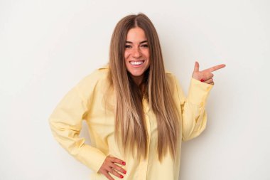 Beyaz arka planda izole edilmiş genç bir Rus kadın işaret parmağıyla işaret ederek gülümsüyor..