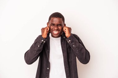 Genç Afrikalı Amerikalı adam beyaz arka planda izole edilmiş kulakları elleriyle kapatıyor..