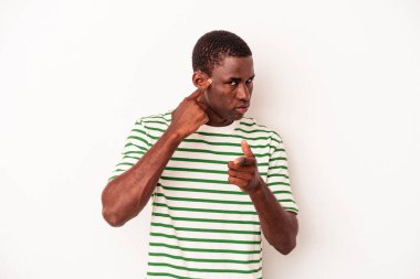 Beyaz arka planda izole edilmiş genç Afro-Amerikan bir adam şakağı parmağıyla işaret ediyor, düşünüyor ve bir göreve odaklanıyor..