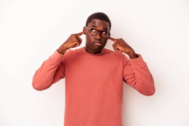 Genç Afrikalı Amerikalı bir adam beyaz arka planda izole edilmiş parmaklarıyla kulaklarını kapatan, yüksek sesli bir ortam tarafından stresli ve umutsuz..