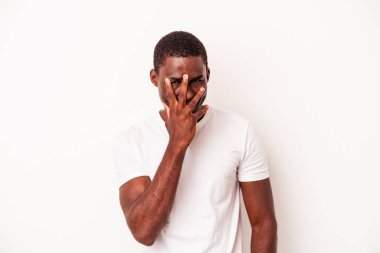 Genç Afrikalı Amerikalı adam beyaz arka planda izole edilmiş. Kameraya parmaklarıyla göz kırpıyor. Yüzünü kapatmaktan utanıyor..