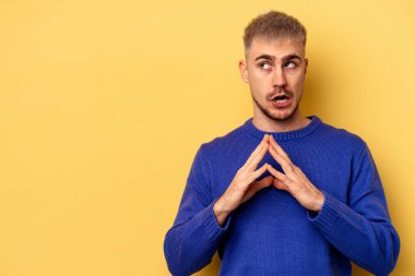 Kafkasyalı genç bir adam sarı arka planda izole edildi. Aklında bir plan oluşturdu..