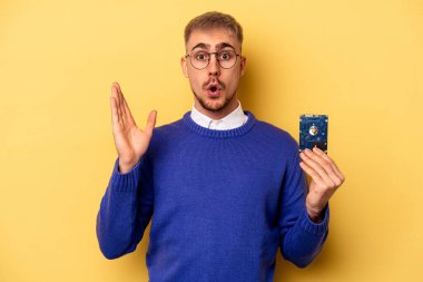 Young computer man isolated on yellow background surprised and shocked.