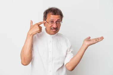 Middle aged indian man isolated on white background holding and showing a product on hand.