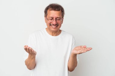 Middle aged indian man isolated on white background holding something with palms, offering to camera.