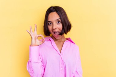 Sarı arka planda izole edilmiş genç bir ırk kadını göz açıp kapayıncaya kadar elinde iyi bir el hareketi tutuyor..