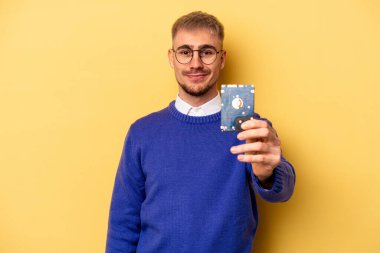 Young computer man isolated on yellow background