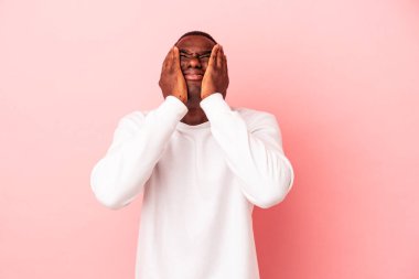 Genç Afro-Amerikalı adam pembe arka planda yalnız başına sızlanıyor ve ağlıyordu..