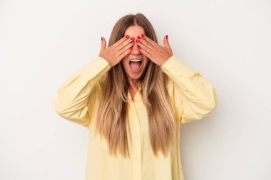 Beyaz arka planda izole edilmiş genç bir Rus kadın elleriyle gözlerini kapatıyor, geniş bir gülümsemeyle bir sürpriz bekliyor..