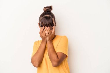 Beyaz arka planda izole edilmiş genç bir ırk kadını parmaklarıyla kameraya göz kırpıyor ve yüzünü kapatmaktan utanıyor..