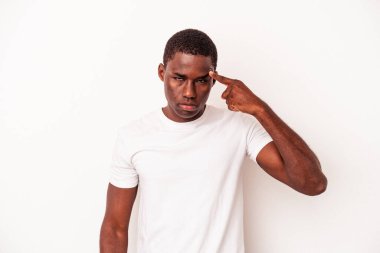 Beyaz arka planda izole edilmiş genç Afro-Amerikan bir adam şakağı parmağıyla işaret ediyor, düşünüyor ve bir göreve odaklanıyor..