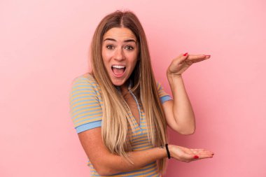 Pembe arka planda izole edilmiş genç bir Rus kadın rahat bir şekilde fotokopi odasına bakan bir şey düşünüyor..