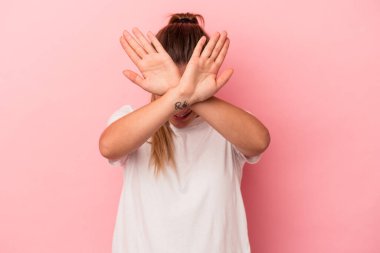 Pembe arka planda izole edilmiş genç Rus kadın iki kolu çapraz tutuyor, inkar kavramı.