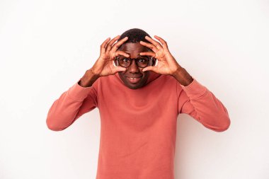 Beyaz arka planda izole edilmiş genç Afro-Amerikan bir başarı fırsatı bulmak için gözlerini açık tutuyor..