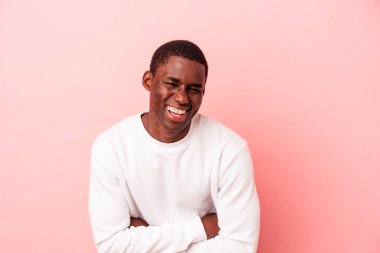 Genç Afrikalı Amerikalı adam pembe arka planda izole edilmiş gülüyor ve eğleniyor..